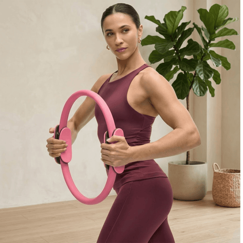 Woman performing pilates ring magic circle exercise