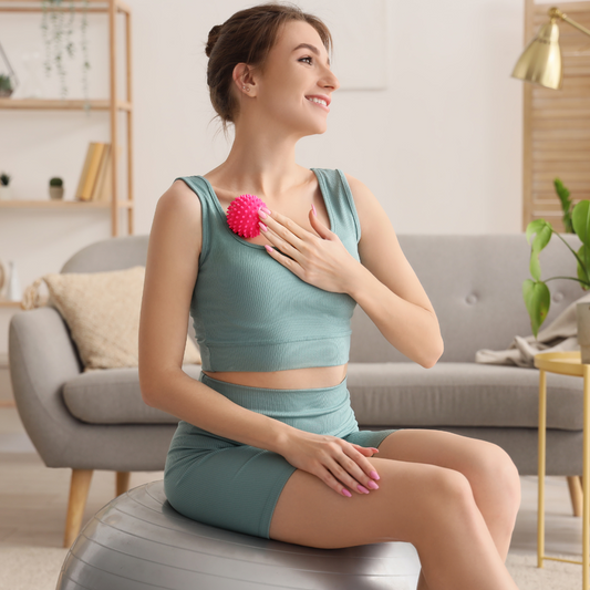 Woman using a pink acupressure massage ball on chest for muscle relief – The Fit Fab Co